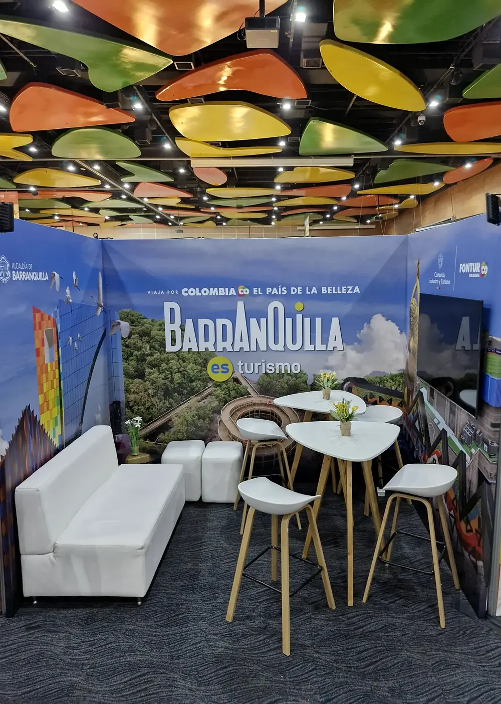 Stand de Barranquilla es turismo con sala, mesas y gráfica de la ciudad